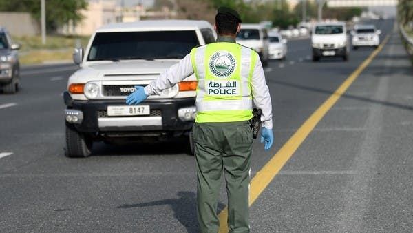 A policeman stops vehicles at a security checkpoint to examine passengers for exit permits in Dubai on April 9. (AFP)