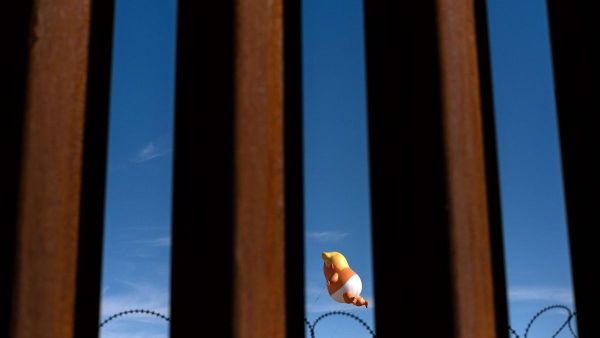 A Donald Trump balloon glimpsed through the US-Mexico border fence. Guillermo Arias / AFP