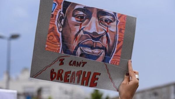 A woman holds a placard depicting George Floyd's face and reading "I can't breathe" in Bordeaux, on June 9, 2020. (AFP)