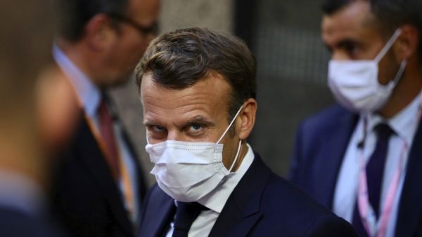 French President Emmanuel Macron, center, leaves the European Council building in the early morning during an EU summit in Brussels, on July 20, 2020. Leaders from 27 European Union nations met throughout the night of July 19 to assess an overall budget and recovery package spread over seven years estimated at some 1.75 trillion to 1.85 trillion euros. The summit will continue into it's fourth day on Monday. Olivier Matthys / POOL / AFP
