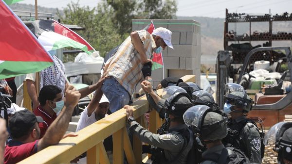 Israeli border guards stop a Palestinian demonstrator from crossing a barrier during a rally to protest Israel's plan to annex parts of the occupied West Bank, in the Palestinian village of Haris, southwest of Nablus, on July 24, 2020. JAAFAR ASHTIYEH / AFP