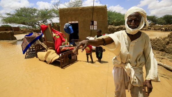 A Sudanese man stands next to his furniture, after torrential rain lead to landslides and flash floods, in the town of Umm Dawan Ban, southeast of the capital Khartoum on August 2, 2020. ASHRAF SHAZLY / AFP