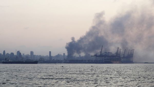 A picture taken from the coastal road on the northern outskirts of Beirut shows smoke billowing following an explosion in the heart Lebanese capital on August 4, 2020. Two huge explosion rocked the Lebanese capital Beirut, wounding dozens of people, shaking buildings and sending huge plumes of smoke billowing into the sky. Lebanese media carried images of people trapped under rubble, some bloodied, after the massive explosions, the cause of which was not immediately known.  JOSEPH EID / AFP