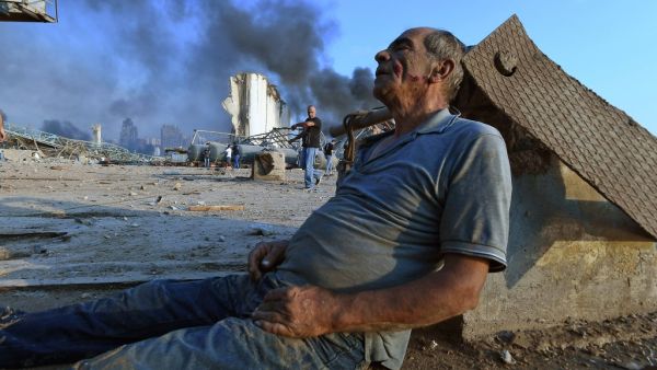 A wounded man sits on the ground waiting for aid at Beirut's port following a massive explosion that hit the heart of the Lebanese capital on August 4, 2020. Rescuers searched for survivors in Beirut on August 5 after a cataclysmic explosion at the port sowed devastation across entire neighbourhoods, killing more than 100 people, wounding thousands and plunging Lebanon deeper into crisis. AFP