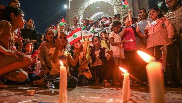 Palestinians attend a candle light vigil in Rafah in the southern Gaza Strip on August 5, 2020, in support of Lebanon a day after a blast in a warehouse in the port of the Lebanese capital sowed devastation across entire city neighbourhoods. SAID KHATIB / AFP