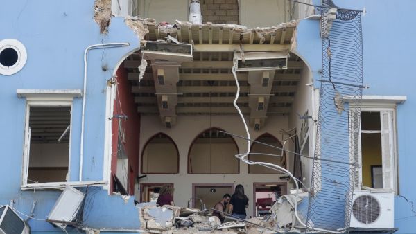 A Lebanese couple inspect the damage to their house in an area overlooking the destroyed Beirut port on August 5, 2020 in the aftermath of a massive explosion in the Lebanese capital. (JOSEPH EID / AFP)