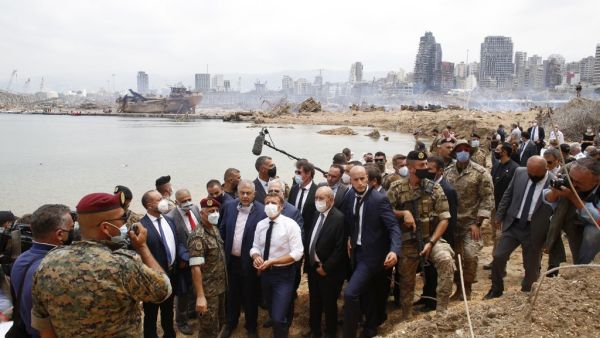 French President Emmanuel Macron (C), flanked by French Foreign Affairs Minister Jean-Yves Le Drian (C,R) visits the devastated site of the explosion at the port of Beirut, on August 6, 2020 two days after a massive explosion devastated the Lebanese capital in a disaster that has sparked grief and fury. French President Emmanuel Macron visited shell-shocked Beirut on August 6, pledging support and urging change after a massive explosion devastated the Lebanese capital in a disaster that left 300,000 people 