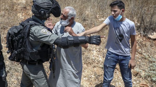 A member of Israeli security argues with a Palestinian demonstrator during a rally to protest Israel's plan to annex parts of the occupied West Bank, in the Palestinian village of Haris, southwest of Nablus, on August 7, 2020. JAAFAR ASHTIYEH / AFP