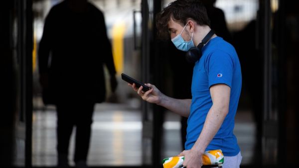 A face mask-clad pedestrian walks in Wellington's central business district in on August 12, 2020. New Zealand's dream run of 102 days without locally transmitted coronavirus ended on August 11, prompting a stay-at-home lockdown order for the country's largest city. Marty MELVILLE / AFP