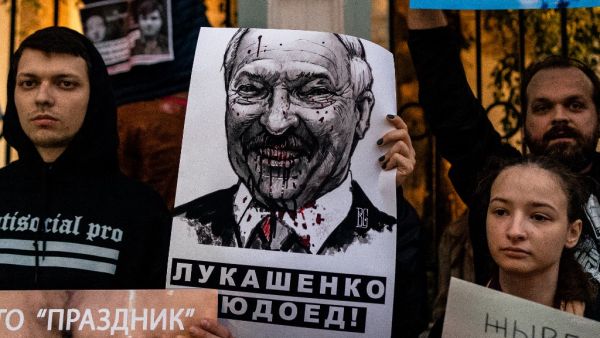 Demonstrators with a placard with an image of Belarus' President Alexander Lukashenko protest against the results of Belarusian presidential election outside the Belarusian embassy in Moscow on August 12, 2020. Dimitar DILKOFF / AFP