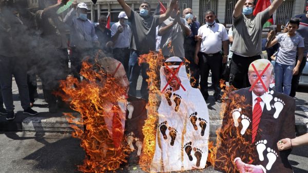 Palestinian protesters set aflame cut-outs showing the faces of (L to R) Israeli Prime Minister Benjamin Netanyahu, Abu Dhabi Crown Prince Sheikh Mohammed bin Zayed al-Nahyan, and US President Donald Trump, during a demonstration in Nablus in the occupied West Bank on August 14, 2020 against a US-brokered deal between Israel and the UAE to normalise relations. The deal marks only the third such accord the Jewish state has struck with an Arab nation, an historic shift making the Gulf state only the third Ara
