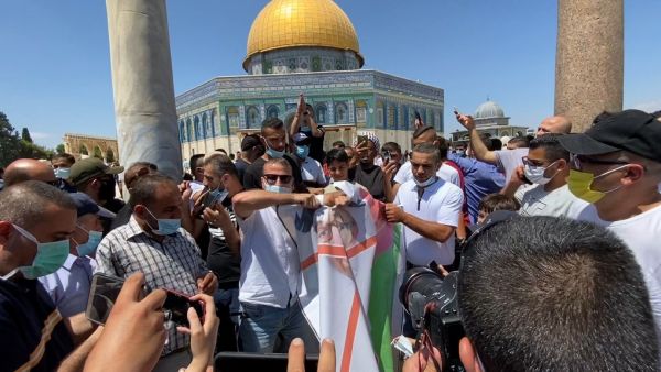 A grab from a AFPTV video shows Palestinian protesters tearing apart a portrait of Abu Dhabi Crown Prince Sheikh Mohammed bin Zayed al-Nahyan on August 14, 2020 at the al-Aqsa mosque compound in Jerusalem, during a protest against a US-brokered deal between Israel and the UAE to normalise relations. AFPTV / AFP