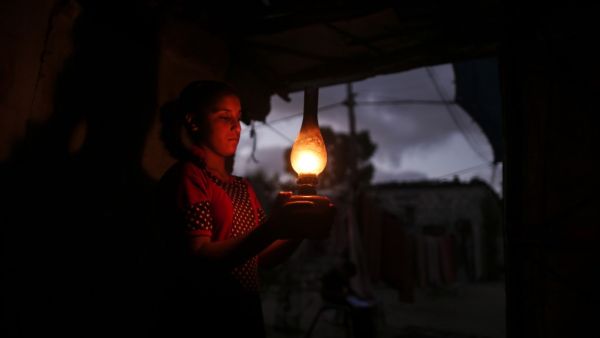 A Palestinian girl uses a gas lamp during a power cut after Gaza's sole power plant shut down amid tension with Israel, in an impoverished household in Khan Yunis in the southern Gaza Strip, on August 18, 2020. MAHMUD HAMS / AFP