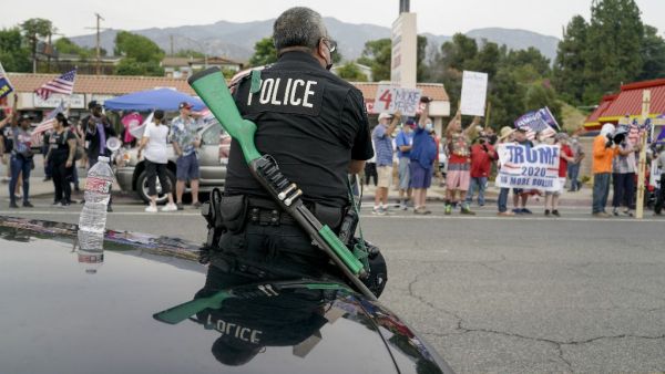 A Los Angeles police officer faces Trump supporters during a pro-Trump rally in Tujunga, a north neighborhood of Los Angeles, August 21, 2020. Kyle Grillot / AFP
