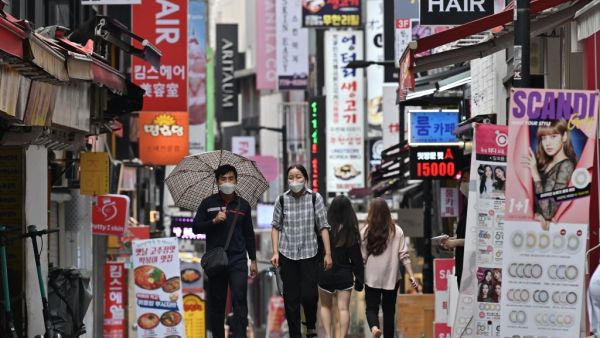 People walk through the Myeongdong shopping district in Seoul on August 27, 2020. South Korea's central bank slashed its growth forecast on August 27, predicting the world's 12th-largest economy will shrink more than one percent this year as it braces for a surge of coronavirus infections. Jung Yeon-je / AFP