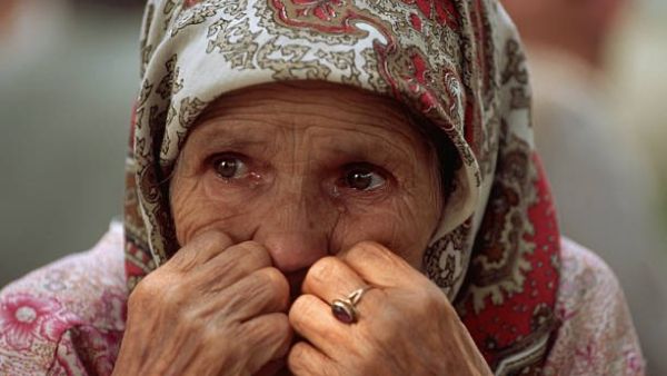 A woman arriving from Srebrenica sits quietly in front of a refugee shelter (Twitter)
