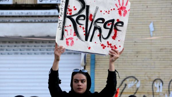 An Iranian regime supporter holds a placard during the final stage of funeral processions for slain top general Qasem Soleimani, in his hometown Kerman, January 7. (AFP)