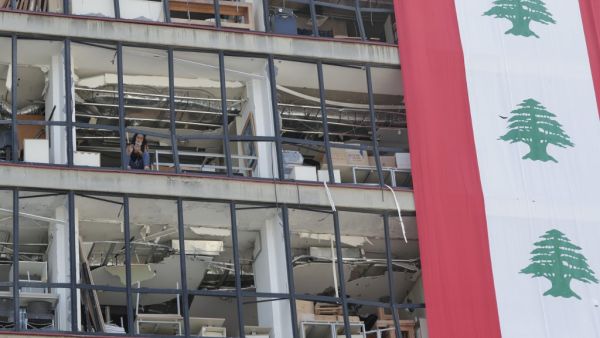 A Lebanese woman checks her phone as she sits in a devastated building in Beirut, on August 25, 2020, in the aftermath of a monster explosion at the port of Lebanon's capital which ravaged the city in early August. ANWAR AMRO / AFP