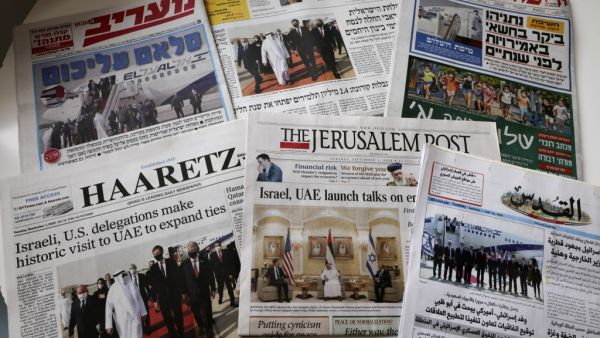 This picture taken on September 1, 2020 in Jerusalem shows the front pages of Israeli and Palestinian newspapers with images of the US-Israeli delegation arriving to Abu Dhabi on the first commercial flight from Tel Aviv to mark the normalisation of ties between the Jewish state and the UAE. MENAHEM KAHANA / AFP