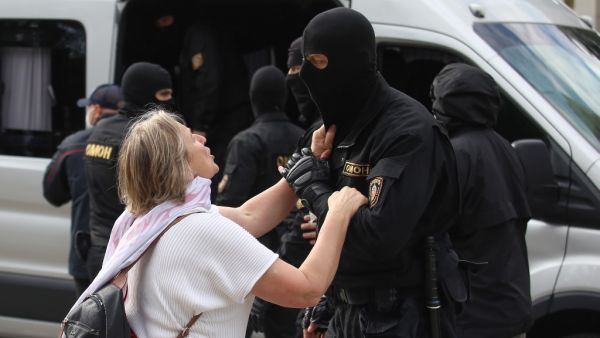 A woman talks to a riot police officer as students protest against presidential elections results in Minsk on September 1, 2020. TUT.BY / AFP