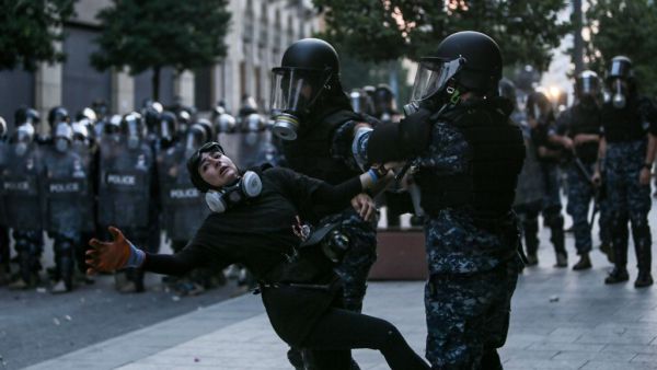 Lebanese riot police restrain a protester during an anti-government demonstration in central Beirut on September 01, 2020. AFP