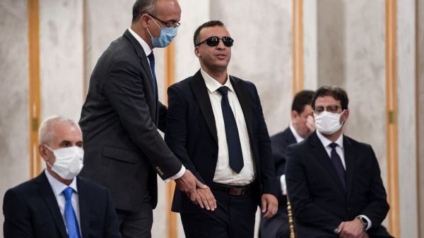 Tunisia's Culture Minister Walid Zidi (who is blind) is assisted to take the oath of office during the new government swearing-in ceremony at Carthage Palace on the eastern outskirts of the capital Tunis on September 2, 2020, following a confidence vote by parliament. FETHI BELAID / AFP