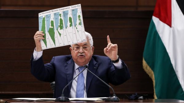 Palestinian president Mahmud Abbas holds a placard showing maps of (L to R) historical Palestine, the 1947 United Nations partition plan on Palestine, the 1948-1967 borders between the Palestinian territories and Israel, and a map of US President Donald Trump's proposal for a Palestinian state under his new peace plan, as he speaks in the West Bank's Ramallah on September 3, 2020, as he meets by video conference with representatives of Palestinian factions gathered at the Palestinian embassy in Beirut in ra