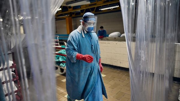 A worker walks at the laundry room of the Mexican Institute of Social Security (IMSS), in Mexico City on September 10, 2020 amid the COVID-19 coronavirus pandemic. Cleaning workers also risk their lives in Mexico's pandemic hospitals, knowing that their efforts often go unnoticed. ALFREDO ESTRELLA / AFP