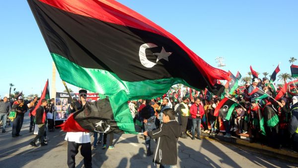 In this file photo taken on February 17, 2020, Libyans wave the national flag as they commemorate the ninth anniversary of the uprising against former Libyan leader Moamer Kadhafi, in Tripoli on February 17, 2020. Mahmud TURKIA / AFP