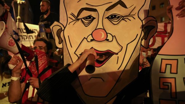 Israeli protesters carry a board with a caricature of their prime minister during an anti-government demonstration in front of Netanyahu's residence in Jerusalem on September 12 2020, demanding that he resign over several corruption indictments and his handling of the coronavirus crisis menahem kahana / AFP