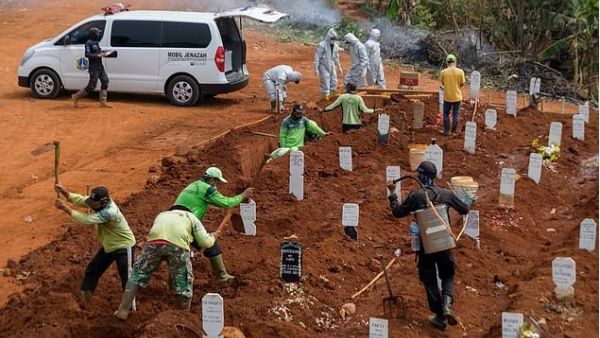 Workers dig holes at a burial site for victims of the Covid-19 coronavirus in Jakarta on September 11 (AFP)