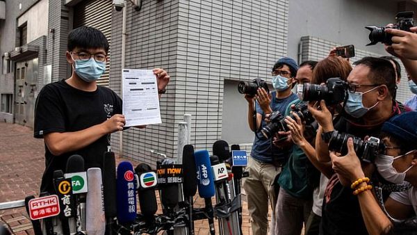 Pro-democracy activist Joshua Wong speaks to the media while holding up a bail document after leaving Central police station in Hong Kong on September 24, 2020. (AFP/File Photo)