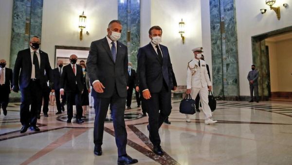 French President Emmanuel Macron (centre right), mask-clad due to the COVID-19 pandemic, arrives for a meeting with Iraq's Prime Minister Mustafa al-Kadhimi (centre left) in the capital Baghdad on September 2, 2020. (GONZALO FUENTES / POOL / AFP)