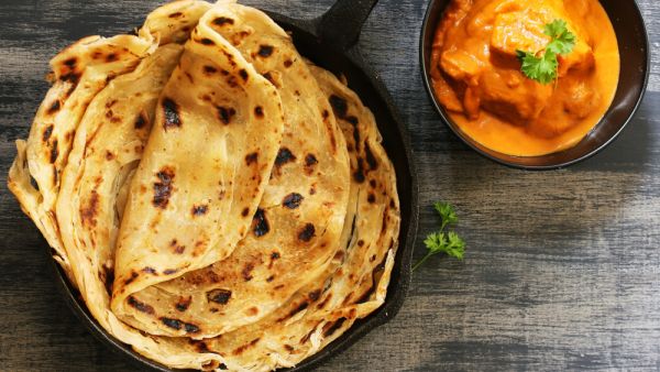 Homemade Kerala wheat paratha or layered parotta / flat bread served with Paneer curry (Shutterstock)