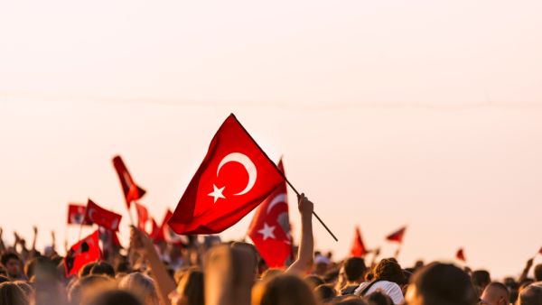 Crowded people in the square of Gundogdu and Turkish flags in crowded people  (Shutterstock)	