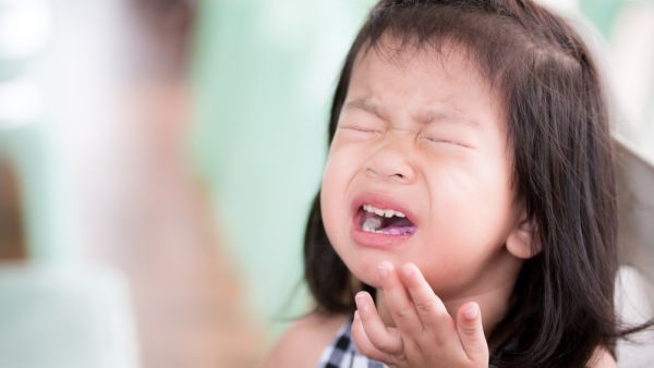 The Chinese girl is seen making a sour face while holding her tongue with her hand, seemingly overwhelmed by how spicy the chilli was. (Shutterstock)