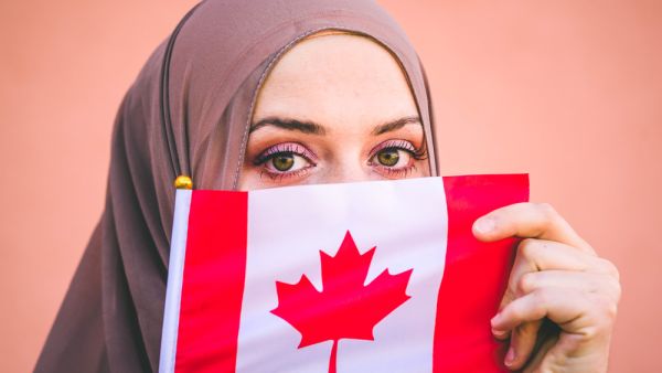 Muslim woman in hijab holds flag of Canada (Shutterstock/ File Photo)