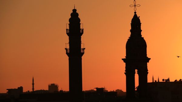 A minaret and bell tower silhouette (Shutterstock/ File Photo)