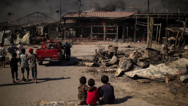 Children sit on the ground in the burnt camp of Moria on the island of Lesbos after a major fire broke out, on September 9, 2020. (AFP/File Photo)