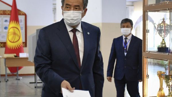 Kyrgyz President Sooronbay Jeenbekov wearing a face mask casts his ballot at a polling station during parliamentary election in Bishkek on October 4, 2020, amid the ongoing coronavirus pandemic. Vladimir VORONIN / POOL / AFP