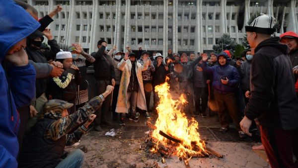 People protesting the results of a parliamentary vote gather by a bonfire in front of the seized main government building, known as the White House, in Bishkek, on October 6, 2020. Kyrgyzstan was deep in political crisis Tuesday with its pro-Russian president insisting he was in control despite protesters capturing the seat of government and freeing his predecessor and nemesis following violent clashes with police. VYACHESLAV OSELEDKO / AFP