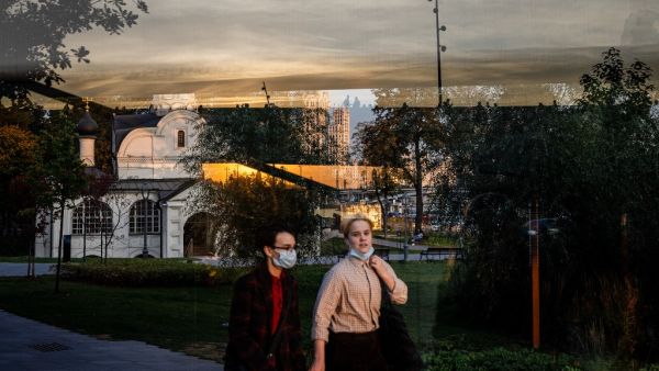 A couple wearing face masks enjoys a warm evening in central Moscow on October 5, 2020, amid the ongoing coronavirus disease (COVID-19) pandemic. Dimitar DILKOFF / AFP