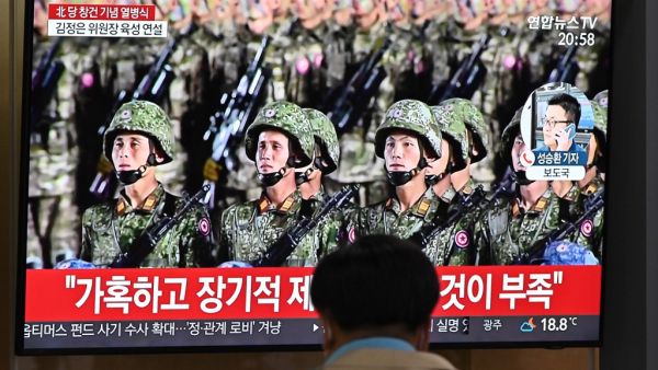 A man watches a television news broadcast of a military parade commemorating the 75th anniversary of North Korea's ruling Workers' Party held in Pyongyang, at a railway station in Seoul on October 10, 2020. Nuclear-armed North Korea held a giant military parade on October 10, television images showed, with thousands of maskless troops defying the coronavirus threat and Pyongyang expected to put on show its latest and most advanced weapons. Jung Yeon-je / AFP