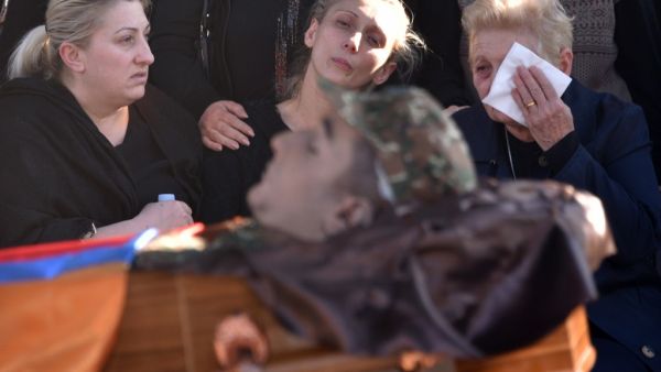 Relatives react by the coffin of soldier Vazgen Aslanyan, who was killed in the fighting between Armenia and Azerbaijan over the breakaway region of Nagorno-Karabakh, during a funeral ceremony at Yerablur military pantheon in Yerevan on October 10, 2020. Karen MINASYAN / AFP