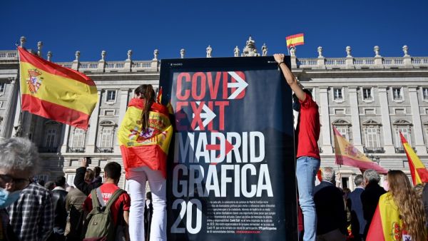 People protest against the Spanish government's handling of the nation's coronavirus outbreak outside the Royal Palace in Madrid during Spain's National Day ceremony on October 12, 2020. Gabriel BOUYS / AFP