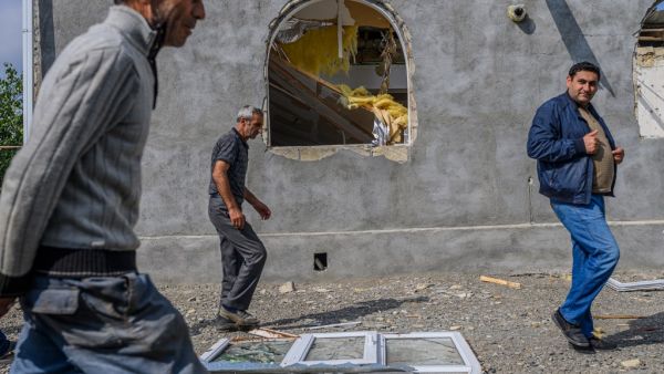 Men pass in front of a house destroyed by shellings in the village of Bakharly, near Agdam city during the ongoing fighting between Armenia and Azerbaijan over the disputed region, in the city of Terter on October 14, 2020. Azerbaijan said on October 14, 2020 it had destroyed missile launchers inside Armenia that were targetting its cities, as fierce fighting over Nagorno-Karabakh risked widening beyond the disputed region. Hundreds have already lost their lives in two weeks of fighting, and continued clash
