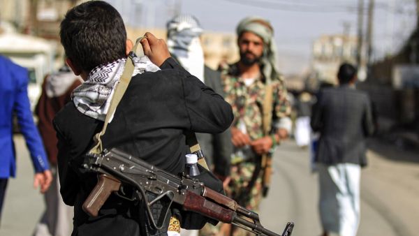 In this file photo a Yemeni boy adjusts on his shoulder the strap of a Kalashnikov assault rifle as he attends a demonstration in the Huthi rebel-held capital Sanaa on January 31, 2020, against a US-brokered proposal for a settlement of the Israeli-Palestinian Middle East conflict. Yemen's Huthi rebels on October 14, 2020 freed two captive Americans, the White House said, in what was reported to be a swap in which Saudi Arabia freed some of the group's supporters. "The United States welcomes the release tod