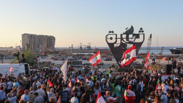 Lebanese protesters gather to light the "October 17 torch" marking the one year anniversary of the beginning of a nationwide anti-government protest movement, in front of the devastated port of the capital Beirut where a massive explosion took place more than two months ago, on October 17, 2020. ANWAR AMRO / AFP
