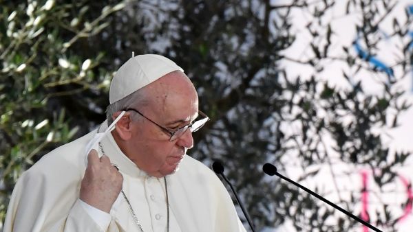 Pope Francis takes off his face mask prior to delivering a speech during a ceremony for peace with representatives from various religions in Campidoglio Square in Rome on October 20, 2020. Andreas SOLARO / AFP