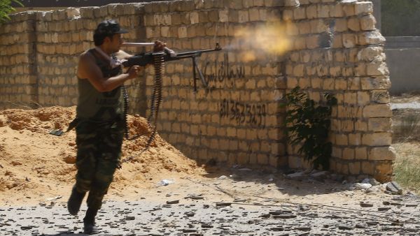 In this file photo taken on September 7, 2019, a fighter loyal to the internationally recognised Libyan Government of National Accord (GNA) fires his gun during clashes with forces loyal to strongman Khalifa Haftar in the capital Tripoli's suburb of Ain Zara. Libya's two warring factions signed a "permanent" ceasefire agreement following five days of talks at the United Nations. Mahmud TURKIA / AFP
